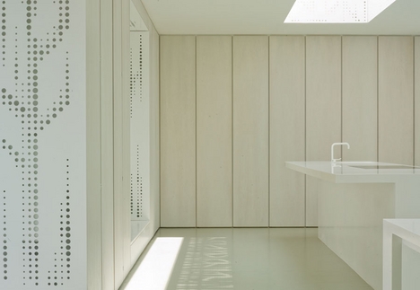 Oak panels in the kitchen contrast with the perforated metal.