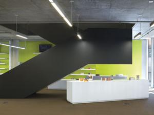 Internal staircases in black painted steel register against partition walls in kiwi-fruit 