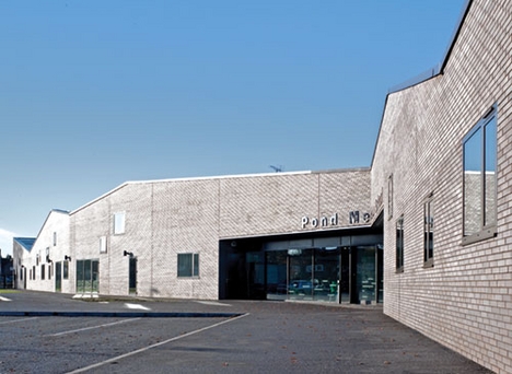 The visitor entrance is cut into the principal elevation, exposing deep brick reveals.