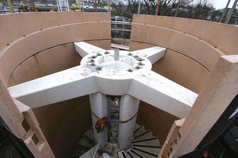 The welded steel cruciform at the top of the spiral staircase is clad in precast concrete, and transfers the load of the outer shell back to the concrete core.