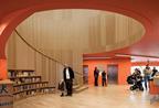 The library entrance is dominated by the sweeping spiral stairwell, lined with oak-veneered acoustic ribs.