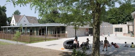 The new building forms a forecourt with the existing house on the right.