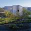 The building emerges from the bottom of a weir at a bend in the River Calder.