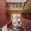 The lofty entrance atrium rises through a series of stepped foyers to the private timber world above.