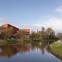 The peak of the theatre’s fly tower rises above the treetops on the bank of the River Lagan.