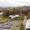 The building nestles into a sloping, wooded site beneath the gothic facade of the former Glasgow Royal Lunatic Asylum.
